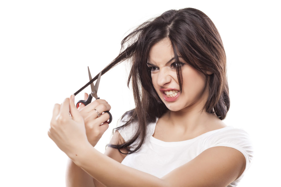 angry girl cuts her hair with scissors